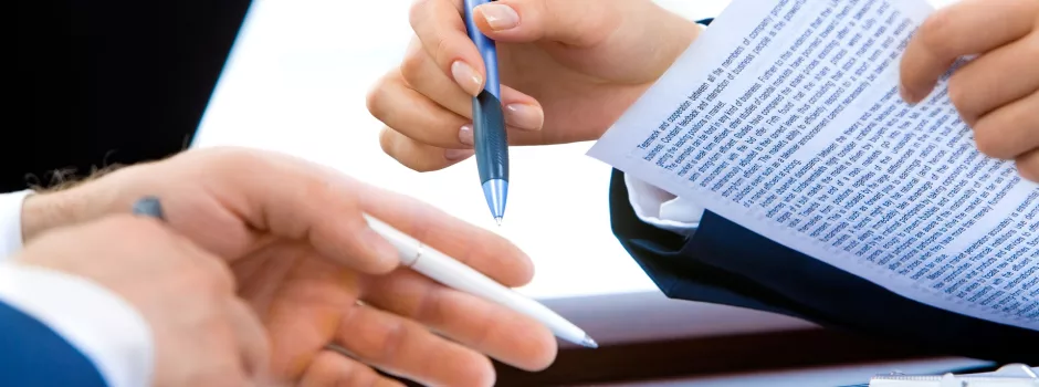 Gros plan sur les mains de personnes en train de signer un contrat de travail.